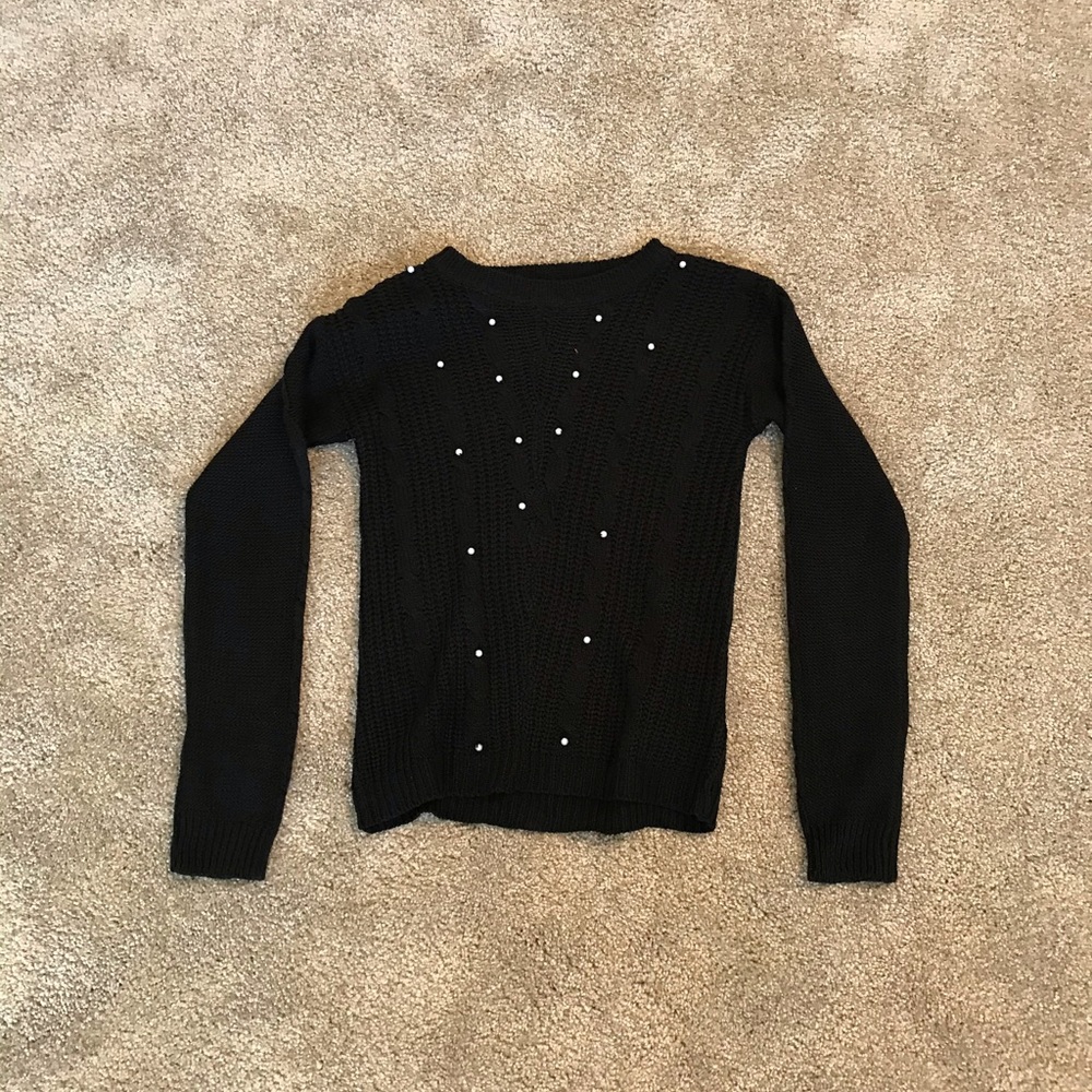 Black sweater with pearls on it.